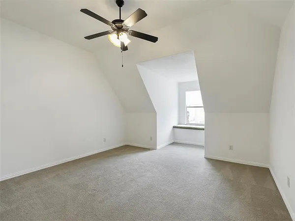 an empty room with a window and a ceiling fan