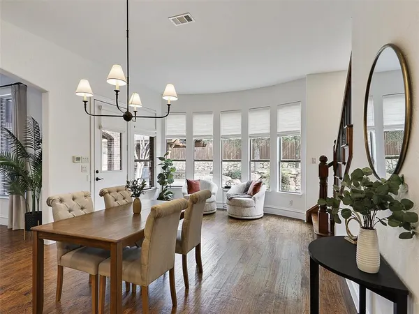 a view of a dining room with furniture a chandelier and wooden floor