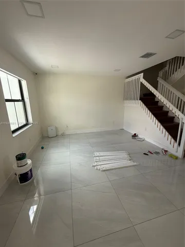a view of hallway with stairs and a window