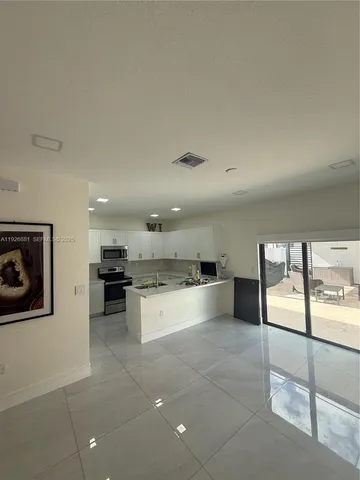 a large kitchen with kitchen island a stove a sink and a refrigerator