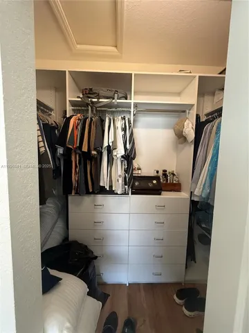 a view of walk in closet with clothes and shoes