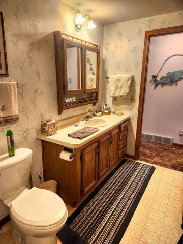 a bathroom with a toilet sink and mirror