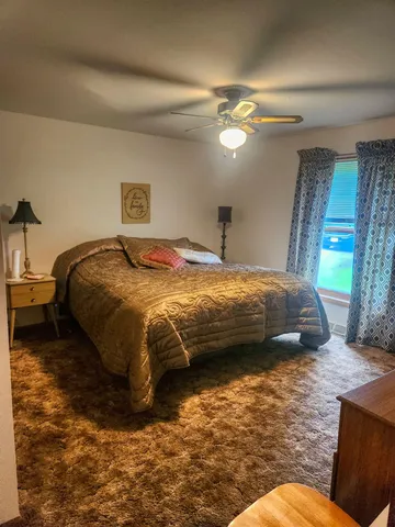 a bedroom with a bed and a chandelier