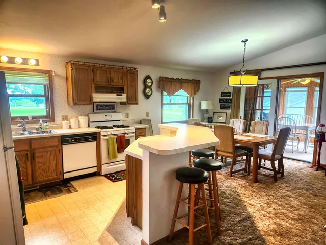 a kitchen with a table chairs sink and cabinets