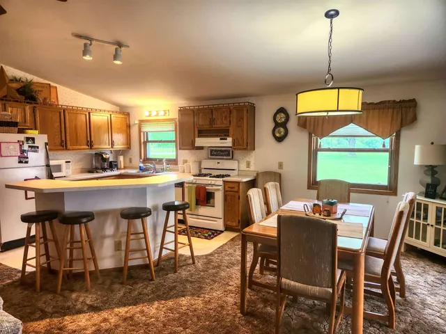 a dining room with a table chairs and a kitchen view