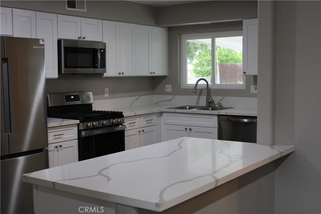 26231 Pine Valley Road Menifee, CA 92586 - Photo 4 of 17 New cabinets, counter tops, stove, microwave and fridge.