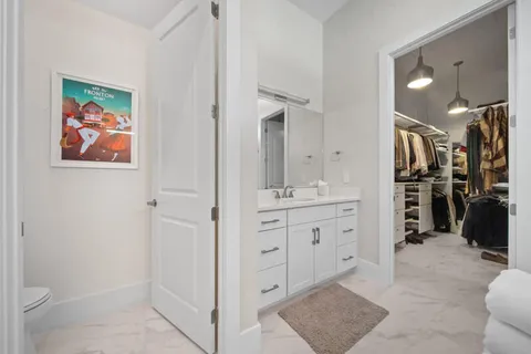 a spacious bathroom with a double vanity sink a toilet and a shower