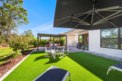 a view of a backyard with table and chairs under an umbrella