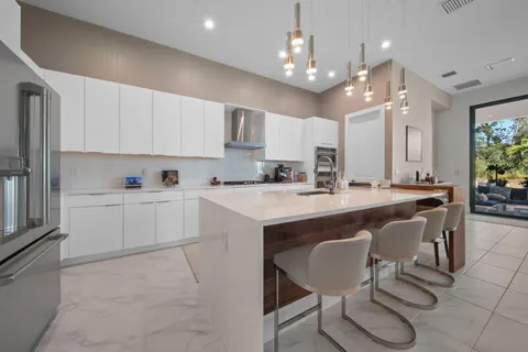 a kitchen with kitchen island granite countertop a sink a center island and cabinets