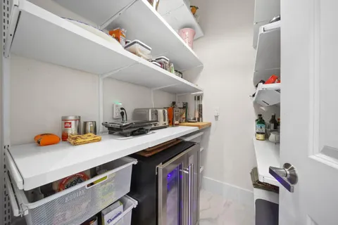 a utility room with stainless steel appliances granite countertop a sink a stove and a wooden floor