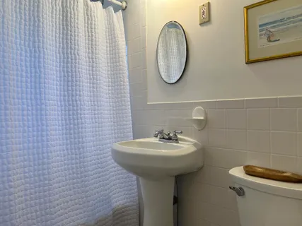 a bathroom with a sink a toilet and a mirror