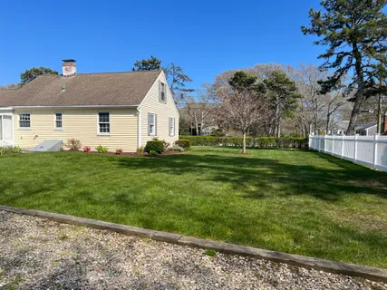 a view of a house with a big yard and potted plants
