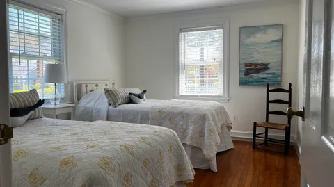 a bedroom with two beds and a large window