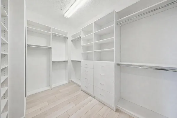a spacious bathroom with a granite countertop sink a mirror a bathtub and shower