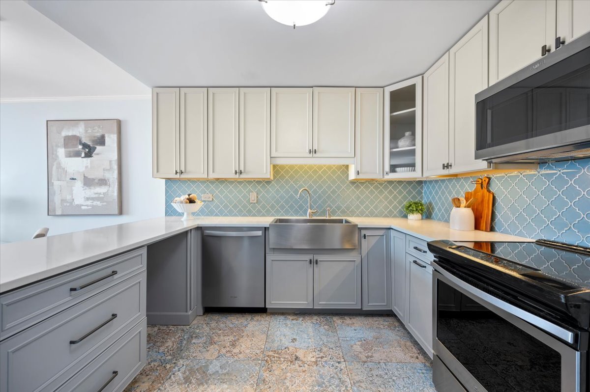 5855 North Sheridan Road, Unit 25G Chicago, IL 60660 - Photo 11 of 29 a kitchen with granite countertop cabinets stainless steel appliances and a sink