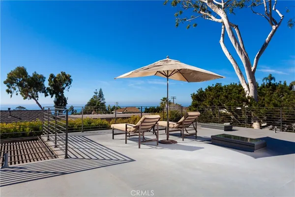 a view of a patio with a table and chairs under an umbrella