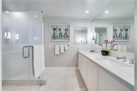 a bathroom with a double vanity sink a mirror and a shower