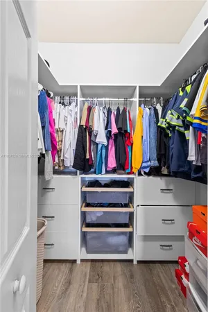 a view of walk in closet with clothes and shoes