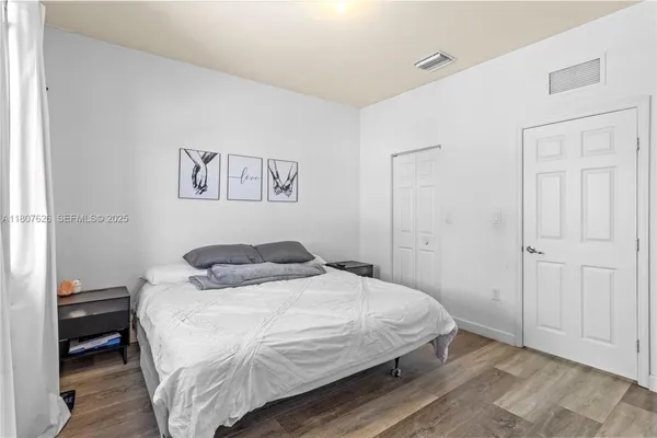 a bedroom with a bed and a painting on the wall