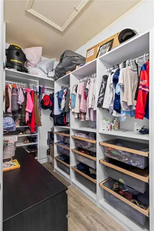 a view of walk in closet with clothes and shoes