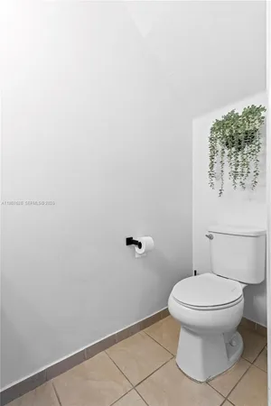 a white toilet sitting next to a white wall
