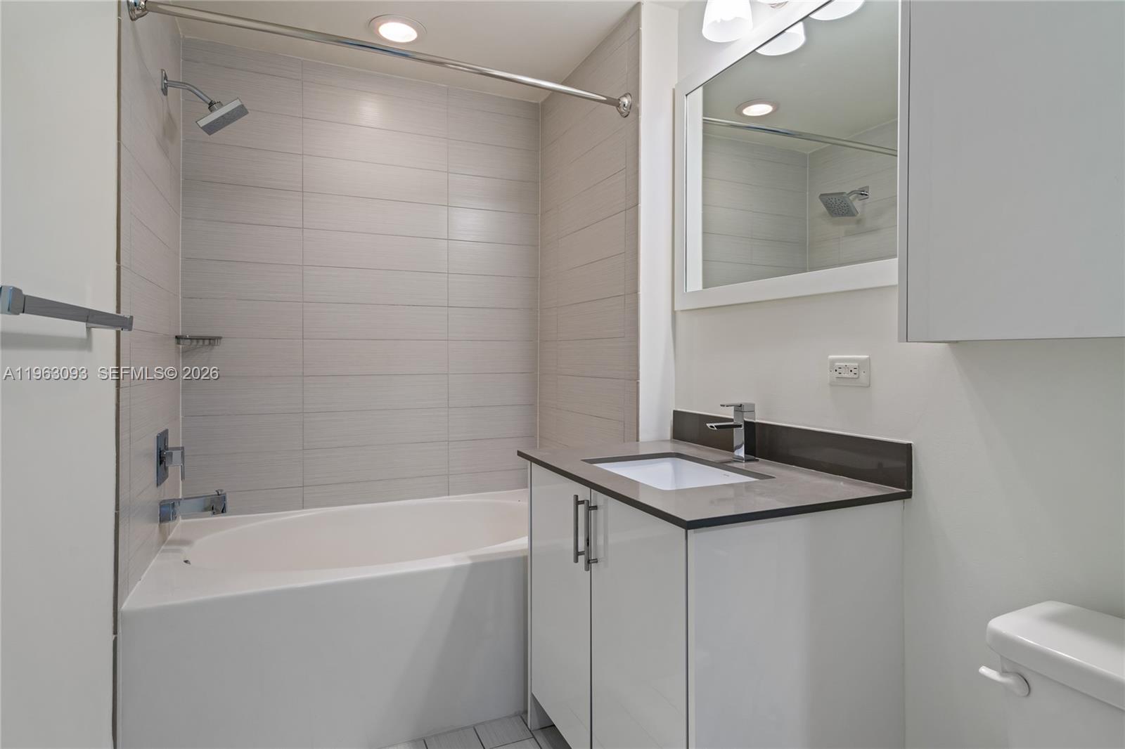999 Southwest 1st Avenue, Unit 2411 Miami, FL 33130 - Photo 26 of 72 a bathroom with a granite countertop sink a toilet and shower