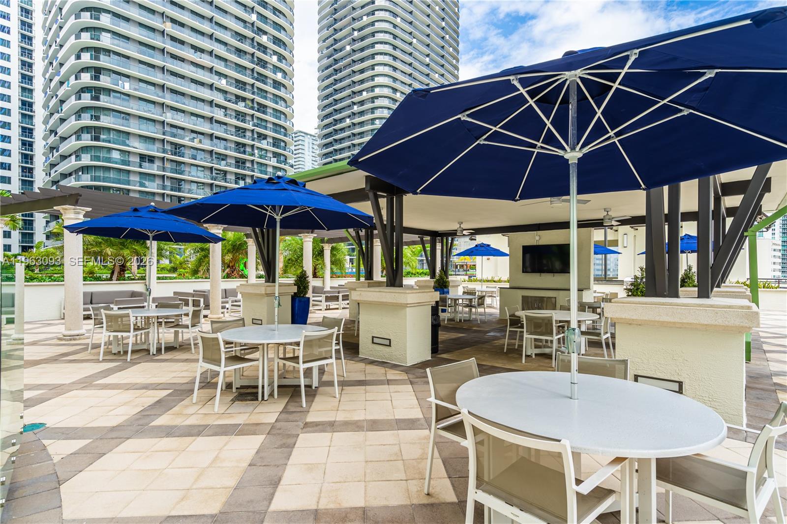 999 Southwest 1st Avenue, Unit 2411 Miami, FL 33130 - Photo 40 of 72 a view of a table and chairs under an umbrella