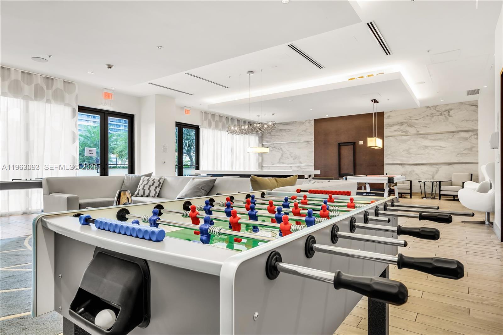 999 Southwest 1st Avenue, Unit 2411 Miami, FL 33130 - Photo 56 of 72 a room with lots of white furniture a rug and a window