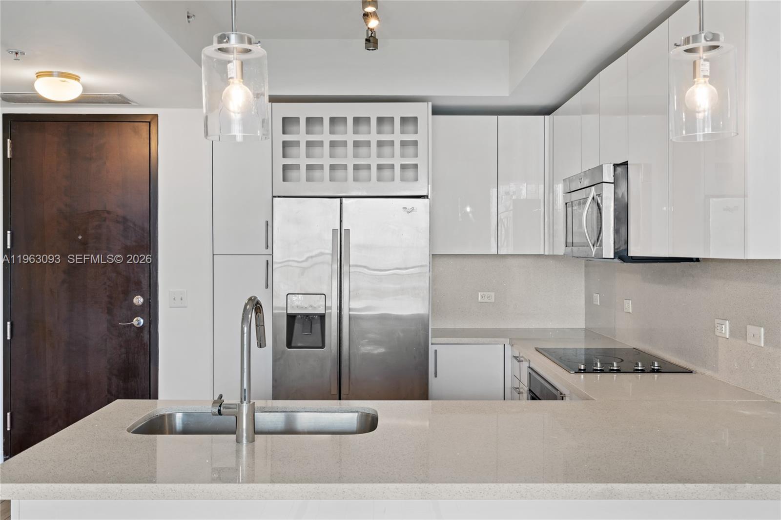 999 Southwest 1st Avenue, Unit 2411 Miami, FL 33130 - Photo 7 of 72 a kitchen with stainless steel appliances kitchen island granite countertop a refrigerator a stove and a sink