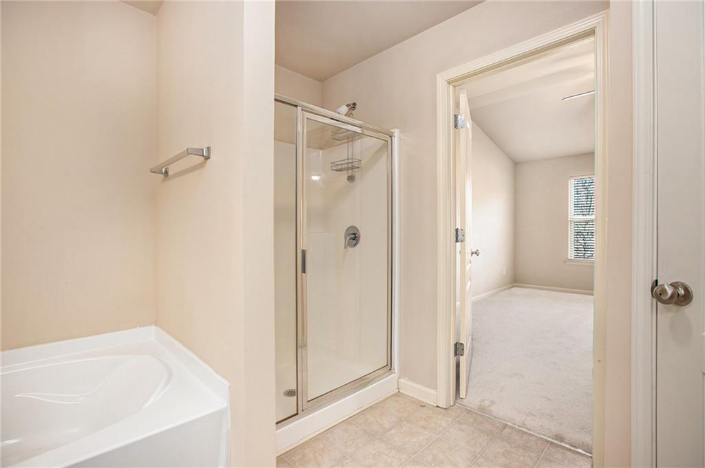 2426 Bellyard Drive Buford, GA 30519 - Photo 18 of 25 a bathroom with a tub shower and a sink