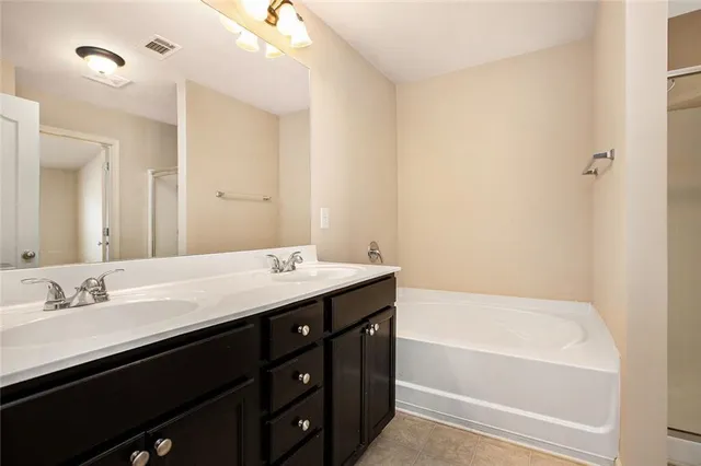 a bathroom with a tub a sink and mirror