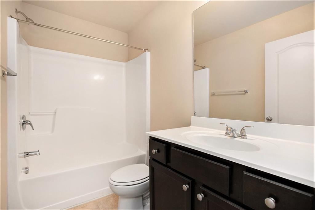 2426 Bellyard Drive Buford, GA 30519 - Photo 22 of 25 a bathroom with a sink a toilet a shower and a mirror