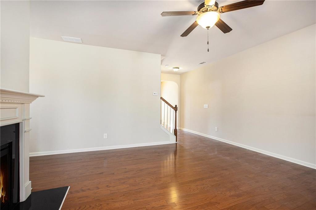 2426 Bellyard Drive Buford, GA 30519 - Photo 6 of 25 a view of an empty room with wooden floor and a ceiling fan