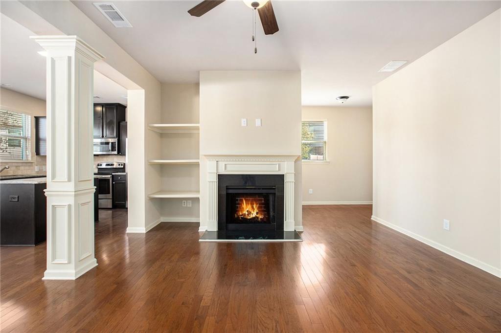 2426 Bellyard Drive Buford, GA 30519 - Photo 8 of 25 an empty room with wooden floor fireplace and windows