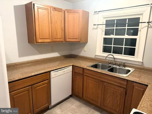 a bathroom with a granite countertop sink toilet and mirror