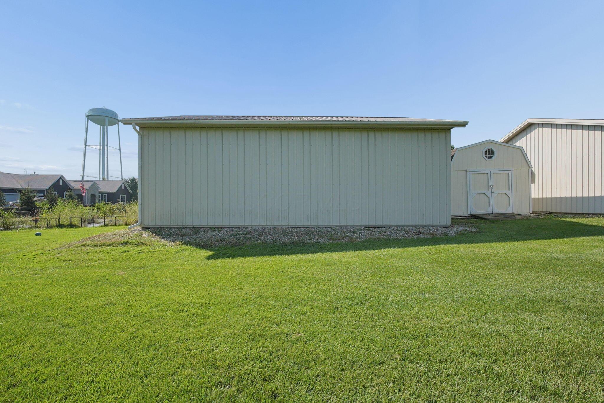 9435 Concord Road Powell, OH 43065 - Photo 56 of 77 Expansive green lawn with a large utility building and an additional storage shed