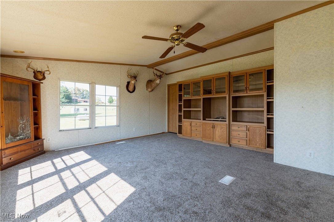 73550 Old Twenty One Road Kimbolton, OH 43749 - Photo 14 of 35 Family room featuring crown molding, carpet flooring, vaulted ceiling, and ceiling fan