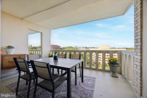 a view of a dining table and chairs in the balcony