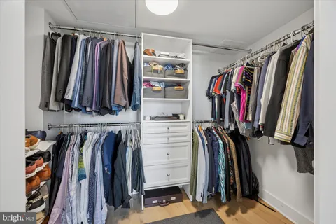 a view of walk in closet with clothes and shoes