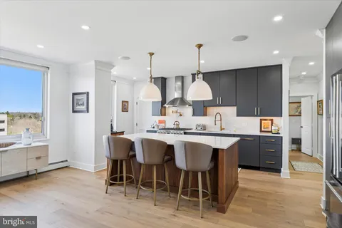a kitchen with stainless steel appliances a sink stove and wooden floor