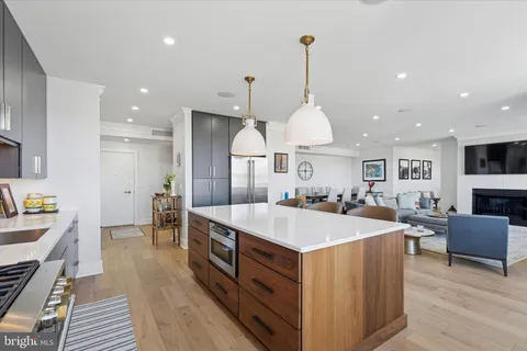 a large kitchen with stainless steel appliances a stove center island a large window and a couch