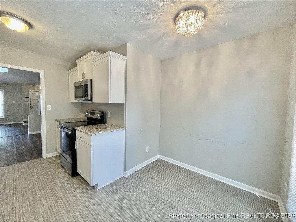 820 Anarine Road, Unit A Fayetteville, NC 28303 - Photo 9 of 22 a kitchen with a refrigerator and a stove top oven
