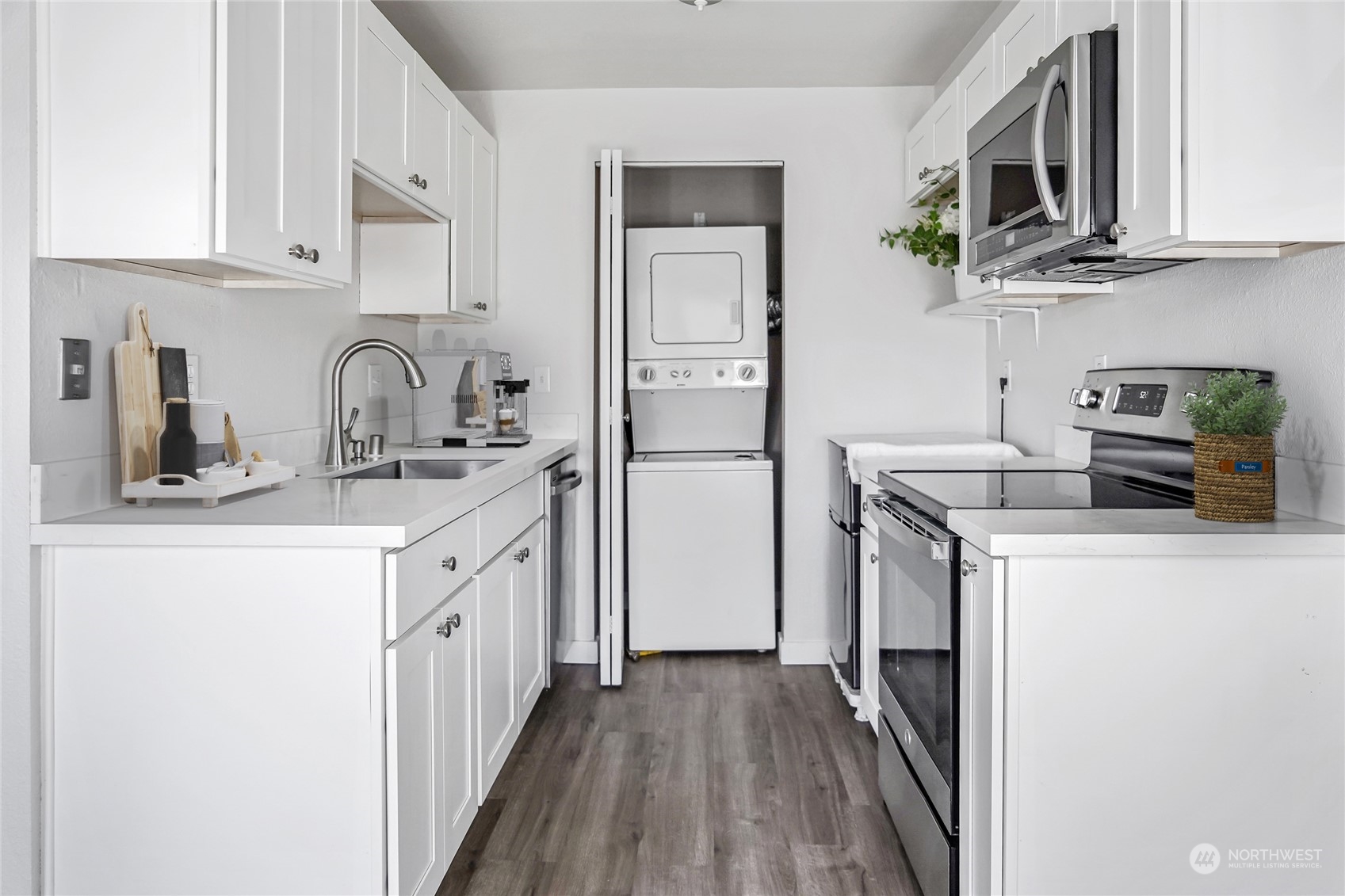 15210 Macadam Road South, Unit D205 Tukwila, WA 98188 - Photo 6 of 11 a kitchen with stainless steel appliances granite countertop a refrigerator sink and white cabinets