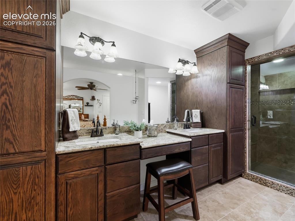 12855 Murphy Road Elbert, CO 80106 - Photo 30 of 50 a bathroom with a granite countertop sink a mirror and a shower