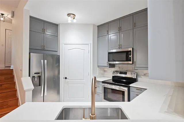 a kitchen with a sink cabinets and stainless steel appliances