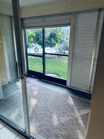 a view of a room with a large window and a tree