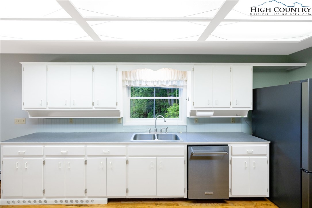 2530 Bear Wallow Road Lansing, NC 28643 - Photo 19 of 48 a kitchen with granite countertop a sink window and cabinets