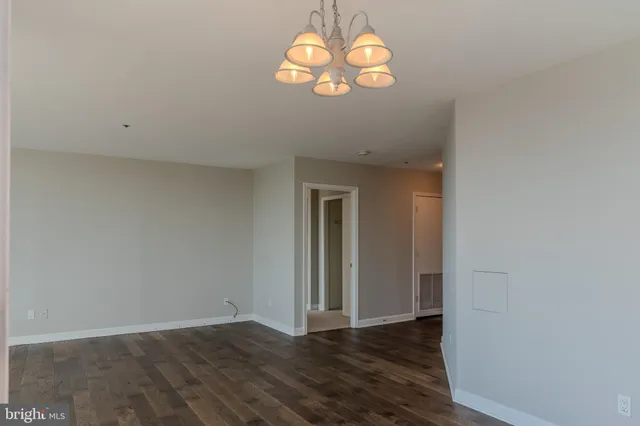 an empty room with wooden floor and window