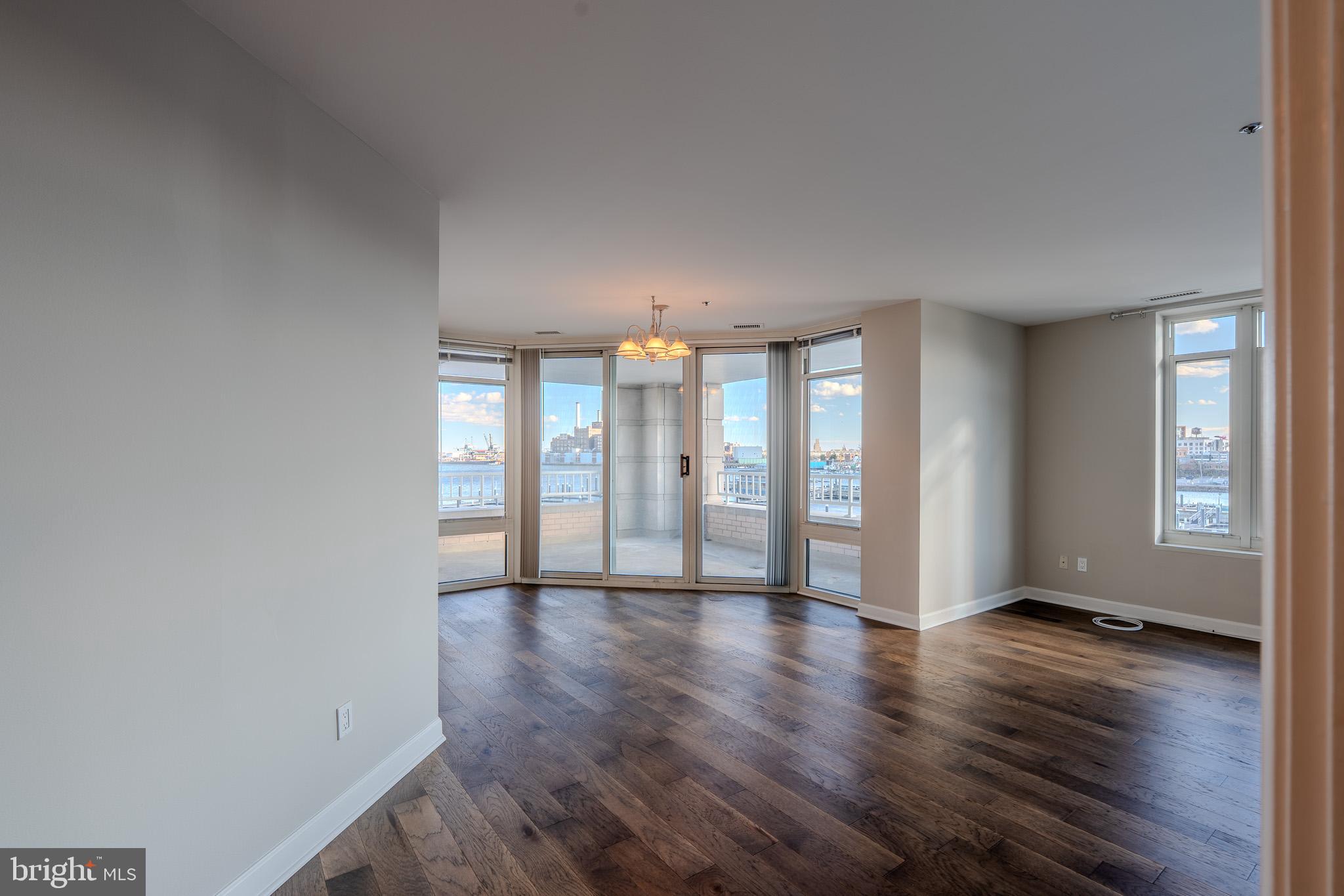 100 Harborview Drive, Unit 302 Baltimore, MD 21230 - Photo 16 of 48 a view of an empty room with wooden floor and a window