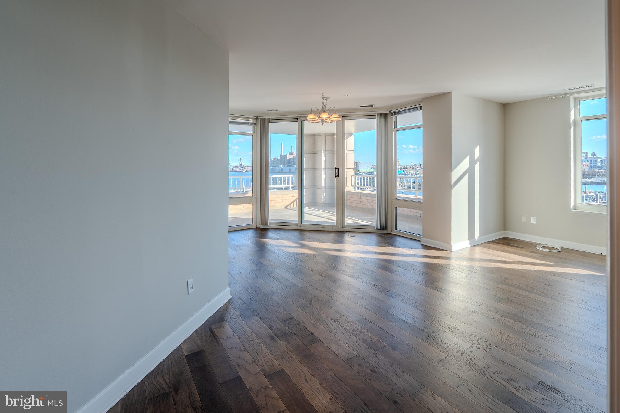 100 Harborview Drive, Unit 302 Baltimore, MD 21230 - Photo 31 of 48 a view of an empty room with wooden floor and a window